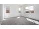 Bright bedroom with gray carpet, three windows, white walls, and ample natural light at 24152 N 172Nd Ave, Surprise, AZ 85387