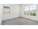 Bright bedroom featuring gray carpet and two windows offering natural light and neighborhood views at 24152 N 172Nd Ave, Surprise, AZ 85387