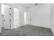 A bedroom with carpet flooring, neutral walls and trim, and two doors that lead to a bathroom and hallway at 24152 N 172Nd Ave, Surprise, AZ 85387
