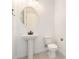 Simple powder room features a pedestal sink, round mirror, and modern fixtures, providing a functional space at 24152 N 172Nd Ave, Surprise, AZ 85387