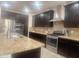 Spacious kitchen with dark wood cabinets, granite countertops, and stainless steel appliances at 24228 S 211Th St, Queen Creek, AZ 85142
