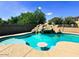 Backyard pool boasts a rock waterfall feature and swim-up table at 24228 S 211Th St, Queen Creek, AZ 85142