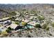 Expansive aerial view of a desert home with a sparkling pool, mature trees, and beautiful mountain views at 2449 E Desert Flower Ln, Phoenix, AZ 85048