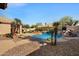 Backyard with a pool, outdoor kitchen, and lush landscaping provides the perfect setting for outdoor entertainment and relaxation at 2449 E Desert Flower Ln, Phoenix, AZ 85048