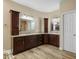 Bathroom featuring matching dark cabinets, granite countertops, and double sinks with a door to the toilet at 2449 E Desert Flower Ln, Phoenix, AZ 85048