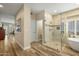 Bright bathroom showcasing a glass-enclosed shower and a luxurious soaking tub with wood-look tile flooring at 2449 E Desert Flower Ln, Phoenix, AZ 85048