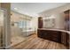 Bathroom featuring a soaking tub, walk-in shower, wood-look floors, and dark cabinets with a light countertop at 2449 E Desert Flower Ln, Phoenix, AZ 85048
