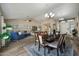Open dining and living room with elegant hardwood floors, comfortable seating, and stylish chandeliers at 2449 E Desert Flower Ln, Phoenix, AZ 85048