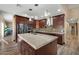 Spacious kitchen with a large island, stainless steel appliances, dark wood cabinets, and stylish pendant lighting at 2449 E Desert Flower Ln, Phoenix, AZ 85048
