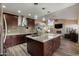 Open concept kitchen with an island, pendant lighting, stainless steel appliances, and a view of the living room at 2449 E Desert Flower Ln, Phoenix, AZ 85048