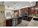 Gourmet kitchen featuring an island with a sink, stainless steel appliances, and a view of the outdoor dining area at 2449 E Desert Flower Ln, Phoenix, AZ 85048