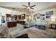 Bright living room featuring a large sectional sofa, modern ceiling fan, and an open layout with the kitchen at 2449 E Desert Flower Ln, Phoenix, AZ 85048