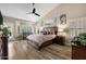 Bright main bedroom with a ceiling fan, ensuite seating area, and large windows, offering a relaxing retreat at 2449 E Desert Flower Ln, Phoenix, AZ 85048