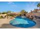 A beautiful freeform pool and spa with a rock waterfall feature and lush landscaping offers a serene backyard escape at 2449 E Desert Flower Ln, Phoenix, AZ 85048
