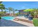 Stunning backyard oasis featuring a sparkling pool, spa, stone accents, and comfortable lounge seating at 2468 W Dapple Gray Ct, San Tan Valley, AZ 85144