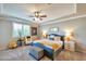 Bright, carpeted bedroom with ceiling fan and blue upholstered bed frame at 2468 W Dapple Gray Ct, San Tan Valley, AZ 85144