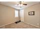 A neutral bedroom with a ceiling fan, window with blinds and exercise equipment on the floor at 2468 W Dapple Gray Ct, San Tan Valley, AZ 85144