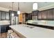 Modern kitchen with dark cabinets, a large island, stainless steel appliances, and sleek countertops at 2468 W Dapple Gray Ct, San Tan Valley, AZ 85144
