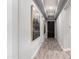 Elegant hallway with modern artwork, tray ceilings, and wood-look tile flooring at 26699 N 104Th Way, Scottsdale, AZ 85262