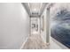 Hallway featuring tray ceilings, wood-look tile flooring, neutral paint, and modern artwork at 26699 N 104Th Way, Scottsdale, AZ 85262