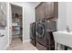 Modern laundry room featuring front load washer and dryer, ample shelving, and a sink at 26699 N 104Th Way, Scottsdale, AZ 85262