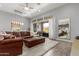Spacious living room with a large leather sectional sofa and access to the outdoor patio at 26699 N 104Th Way, Scottsdale, AZ 85262