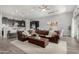 Spacious living room with a large brown leather sectional sofa, and an open layout to the kitchen and dining area at 26699 N 104Th Way, Scottsdale, AZ 85262
