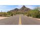 Paved road winds through a beautiful desert landscape with rocky hills in the background at 26699 N 104Th Way, Scottsdale, AZ 85262