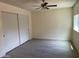 This bedroom has neutral colors, a ceiling fan with lighting, and a large closet with white doors at 2834 E Juanita Ave, Mesa, AZ 85204