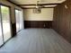 Spacious living area with updated flooring, wood paneling, ceiling fan and sliding glass doors at 2834 E Juanita Ave, Mesa, AZ 85204