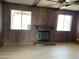 Cozy living room with a wood-paneled wall, brick fireplace, and laminate flooring at 2834 E Juanita Ave, Mesa, AZ 85204