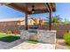 Outdoor kitchen with a built-in grill, stone accents, and a covered patio at 29051 N Shannon Dr, San Tan Valley, AZ 85143
