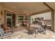 Inviting covered patio with an outdoor kitchen and comfortable seating at 29624 N 128Th Ln, Peoria, AZ 85383