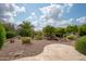 Expansive backyard featuring desert landscaping, a waterfall feature, and a paved patio area at 29624 N 128Th Ln, Peoria, AZ 85383