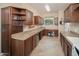 Large laundry room with built-in desk, wine fridge, sink, and plenty of storage space at 29624 N 128Th Ln, Peoria, AZ 85383
