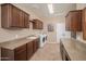 Bright laundry room with front loading washer and dryer, granite countertops, and beautiful wood cabinets at 29624 N 128Th Ln, Peoria, AZ 85383