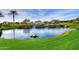 Scenic pond featuring stone waterfall, lush greenery, and tranquil reflections at 29624 N 128Th Ln, Peoria, AZ 85383