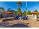 Backyard featuring a hot tub, fire pit, BBQ area, and ample seating under colorful umbrellas at 3150 E Isaiah Ave, Gilbert, AZ 85298