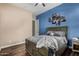 Comfortable bedroom accented by blue walls, fan, and wood-look floors at 3150 E Isaiah Ave, Gilbert, AZ 85298