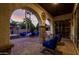 Inviting covered patio with stone arches, cozy seating, fire pit, and outdoor grill area at 3150 E Isaiah Ave, Gilbert, AZ 85298