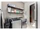 Modern laundry room with gray washer, dryer, open shelving, and ample storage at 3150 E Isaiah Ave, Gilbert, AZ 85298