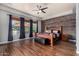 Spacious primary bedroom with wood-look floors, wood accent wall, and large windows for natural light at 3150 E Isaiah Ave, Gilbert, AZ 85298