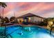Sparkling pool with volleyball net, poolside seating, and palm trees create a backyard paradise at 3150 E Isaiah Ave, Gilbert, AZ 85298