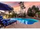 Outdoor oasis featuring a refreshing pool, comfortable lounge chairs, palm trees, and a volleyball net at 3150 E Isaiah Ave, Gilbert, AZ 85298