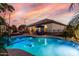 Sparkling pool with volleyball net, poolside seating, and palm trees create a backyard paradise at 3150 E Isaiah Ave, Gilbert, AZ 85298