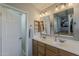 Bright bathroom featuring double sinks, wooden cabinets, and modern fixtures, with view to the main bedroom at 3252 E Lexington Ave, Gilbert, AZ 85234