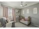 This cozy Bedroom features soft gray walls, pink accents, and a metal crib, creating a tranquil space at 3252 E Lexington Ave, Gilbert, AZ 85234