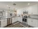 Modern kitchen with stainless steel appliances, white cabinets, and granite countertops at 3252 E Lexington Ave, Gilbert, AZ 85234