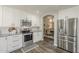 Modern kitchen with white cabinets, stainless steel appliances, and dark wood look floors at 3252 E Lexington Ave, Gilbert, AZ 85234
