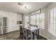 Bright eat-in kitchen with white cabinets, stainless appliances, and a rustic-style dining table at 3252 E Lexington Ave, Gilbert, AZ 85234